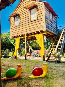 een boomhut met drie rubberen eenden in het gras bij Recanto da Represa Carrancas in Carrancas