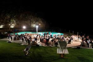 a group of people standing in front of a pool at night at Resort Borgo San Rocco in Savoca  +24 photos