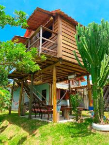 een groot houten huis met banken en een boom bij Recanto da Represa Carrancas in Carrancas