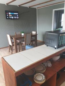 a kitchen with a microwave and a table with chairs at Cabañas La Laguna de Zapallar in La Laguna