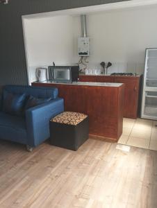 a living room with a blue couch and a kitchen at Cabañas La Laguna de Zapallar in La Laguna