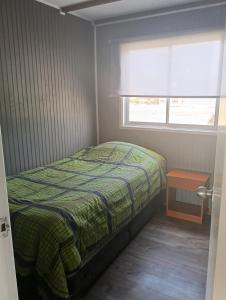 a small bedroom with a bed and a window at Cabañas La Laguna de Zapallar in La Laguna
