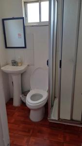 a bathroom with a white toilet and a sink at Cabañas La Laguna de Zapallar in La Laguna +28 photos