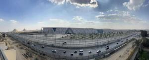 a large building with a road with cars on it at Royal Great Pyramid INN in Cairo