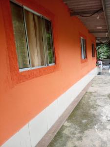 an orange building with windows on the side of it at Casa da Mata in Ubatuba