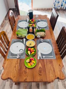 a wooden table with plates of food on it at Sunrise oasis retreat in Habarana +13 photos