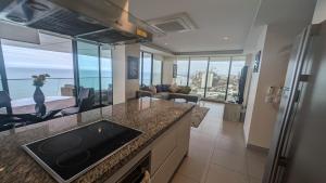 a kitchen and living room with a view of the ocean at Departamento Frente al Mar en Manta Poseidon in Manta