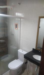イタニャエンにあるCasa com Piscina na Praia Morada do Solのトイレと洗面台を備えた白いバスルーム