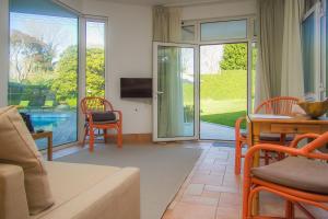 ein Wohnzimmer mit einem Sofa, einem Tisch und einem TV in der Unterkunft Liiiving in Porto | Oporto Garden Pool House in Porto