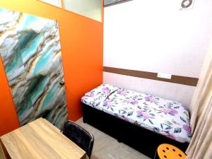 a small room with a bed and a table at Utopia Guest house for men in New Town