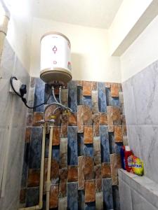 a shower in a bathroom with a tile wall at Utopia Guest house for men in New Town