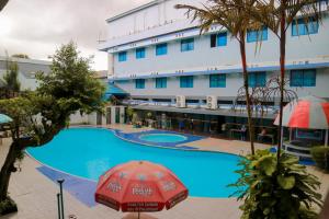 a hotel with a swimming pool and a building at Hotel Mariat Sorong in Sorong