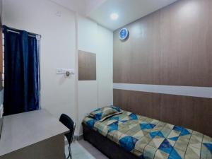 a room with a bed and a table and a desk at Utopia Guest house for men in New Town