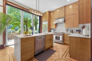 a kitchen with wooden cabinets and a large window at SWJ544FH Huge 6BR 4BA Backyard Access in New York
