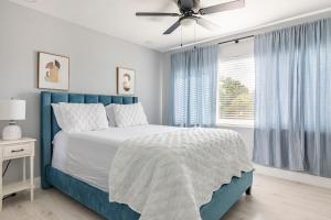 a bedroom with a blue bed and a ceiling fan at Heart of Sunrise and Sawgrass in Sunrise