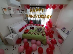 a room with a birthday cake and balloons at Rm Staycation City View SMDC in Kaybagal