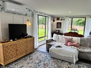 a living room with a couch and a flat screen tv at Lenlie Farm in Howard