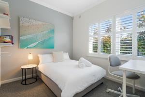 una camera da letto con un letto, una scrivania e finestre di Seaside on Swan - Nespresso Beach Wifi a Grange Altre 21 foto