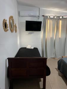 a bedroom with a bed and a flat screen tv at Tres Soles in Salsipuedes