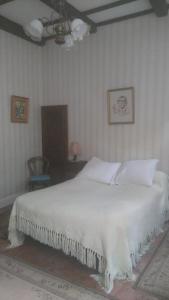 a white bed in a bedroom with a ceiling at hôtel Beaulieu in Viviers