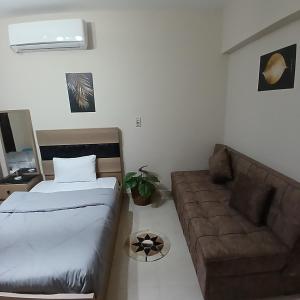 ein Wohnzimmer mit einem Bett und einer Couch in der Unterkunft Fabulous apartment near Gate 20 - El Rehab in Kairo