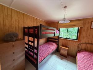 una camera con due letti a castello in una casa di Cabañas Kreuzburg a Futrono