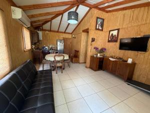 un soggiorno con un tavolo e una tv di Cabañas Kreuzburg a Futrono