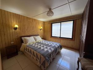 una camera da letto con un letto e una finestra di Cabañas Kreuzburg a Futrono