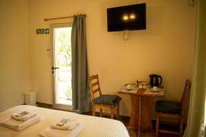 a room with a bed and a table and a window at Dormis:Lodesilvi in Merlo