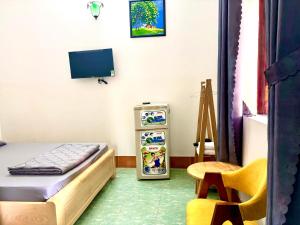 a small room with a bed and a refrigerator at Hotel Minh Vy in Long Hai