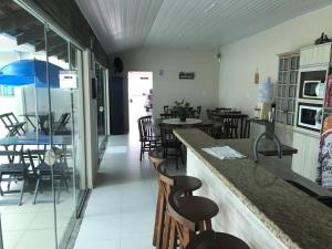 a restaurant with a counter with chairs and tables at Pousada Souza & Souza in Barra Velha