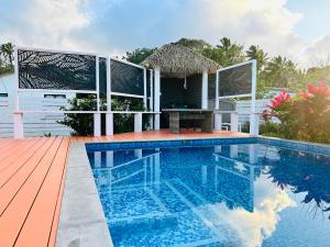 a swimming pool with a table and a house at Itimarama Villas in Vaimaanga