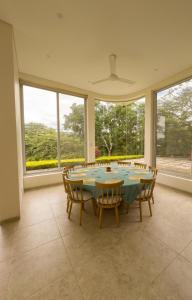 Un comedor con mesa y sillas y ventanas. en Moderna Casa-Paisajes Increíbles, en Anapoima