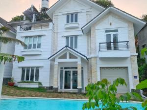 a house with a swimming pool in front of it at 4 Bedrooms Beach Villa in Central Vung Tau in Vung Tau