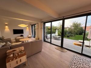 a living room with a couch and a large window at La Maison du Nice Caennais in Caen