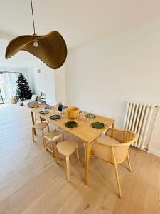 a dining room with a wooden table and chairs at La Maison du Nice Caennais in Caen