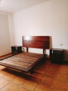 a large wooden bed in a room with two speakers at Cabañas calpulalpan de paso in San Cristóbal Zacacalco