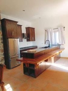 a kitchen with a wooden counter top and a refrigerator at Cabañas calpulalpan de paso in San Cristóbal Zacacalco