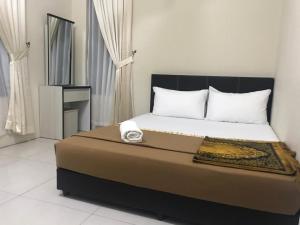 a bedroom with a bed with a clock on it at Ilham Bonda Homestay in Cukai