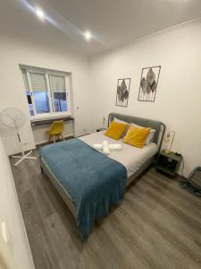 una camera da letto con un letto grande con cuscini gialli di Queluz Maison Jacuzzi Escape a Queluz
