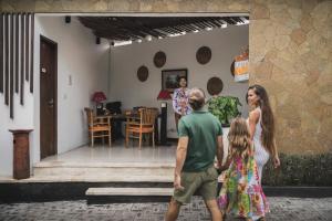 eine Familie steht vor einem Haus in der Unterkunft Canggu Circle Villa by Ini Vie Hospitality in Canggu