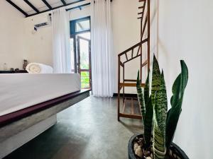 ein Schlafzimmer mit einem Bett und einer Topfpflanze in der Unterkunft Surfside Paddy Villa in Babarenda Central + 43 Fotos