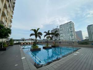 une grande piscine avec des palmiers et des bâtiments dans l'établissement Manhattan Plaza Tower 1, Araneta City Cubao, Quezon City, Metro Manila, à Manille