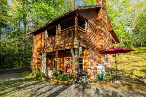 a log cabin with a balcony and an umbrella at FULLY Stocked Home Away From Home! in Gatlinburg