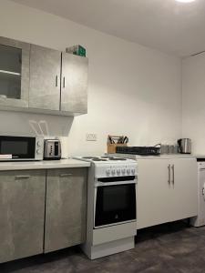 a kitchen with a stove and a microwave at Comfortable One Bedroom Flat in Middlesbrough
