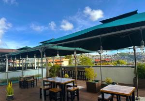 a patio with tables and chairs under a large umbrella at Misty Hills in Baguio