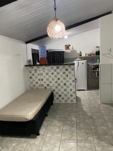 a small bedroom with a bed and a kitchen at Casa em Pipa ( Pipahouse) in Pipa