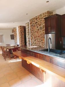 a kitchen with a counter with a sink and a table at Cabañas Calpulalpan de paso in San Cristóbal Zacacalco