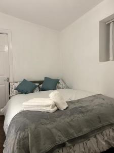 a bedroom with a bed with white sheets and blue pillows at Comfortable One Bedroom Flat in Middlesbrough +5 photos