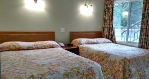 um quarto de hotel com duas camas e uma janela em Snooz Inn em Wilsonville